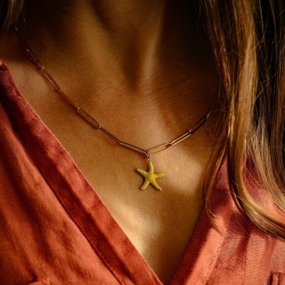 Colar dourado com pendente de estrela-do-mar usado
