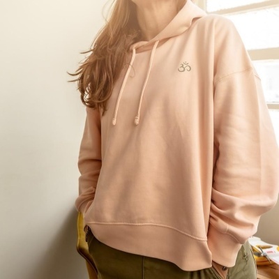 Sweatshirt com capuz rosa claro com símbolo OM em ambiente interior