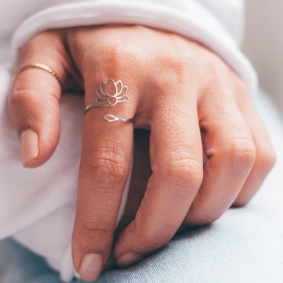 Mão feminina com anel de flor de lótus em prata