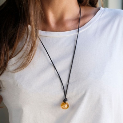 Colar com pendente âmbar e cordão preto usado com t-shirt branca