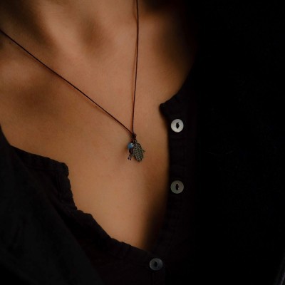 Colar com pendente em forma de mão azul e adornos em pescoço