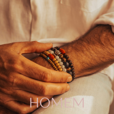 Pulseiras masculinas de contas em madeira e pedras naturais num braço feminino, palavra HOMEM em baixo