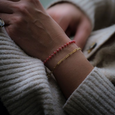 Pulseiras delicadas em pulso com camisola de malha cinza claro