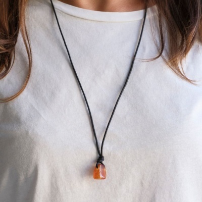 Colar com cordão preto e pendente de pedra laranja