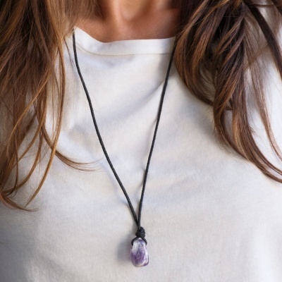Colar com pendente de pedra roxa sobre camiseta branca