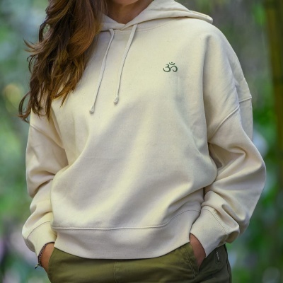 Sweatshirt bege claro com capuz e pequeno símbolo verde OM bordado no peito