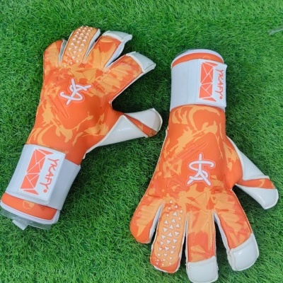 Par de luvas de guarda-redes laranja com detalhes brancos sobre relvado