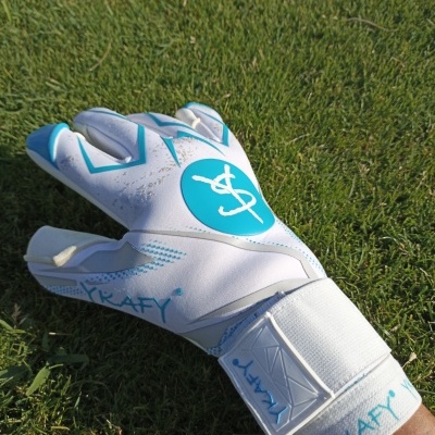 Luva de guarda-redes branca e azul sobre relva