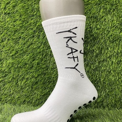 Meia branca com texto YKAFY em preto e detalhes antiderrapantes exibida em manequim