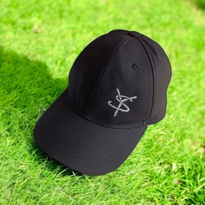 Boné preto com logótipo branco sobre relva