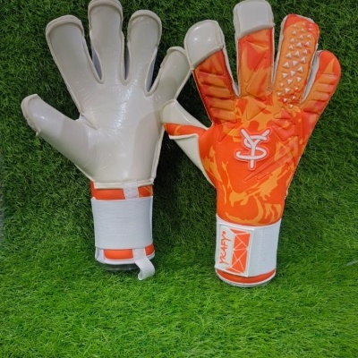 Luvas de guarda-redes em branco e laranja sobre relva artificial