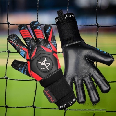 Luvas de guarda-redes de futebol com cores preta, vermelha e azul penduradas numa rede de futebol