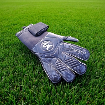 Luvas de guarda-redes pretas sobre relva verde com o texto KRAFTY