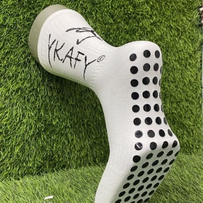 Meia branca antiderrapante com bolinhas pretas na sola e palavra KAFY escrita na lateral