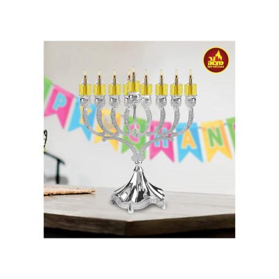 Candeeiro menorá em metal prateado com detalhes dourados sobre mesa de madeira com faixa colorida ao fundo