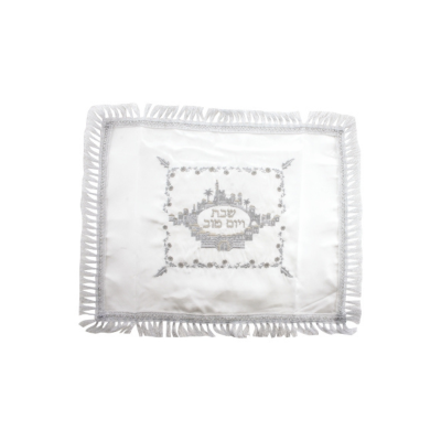 Cobertura branca com franjas e bordado cinza com texto hebraico