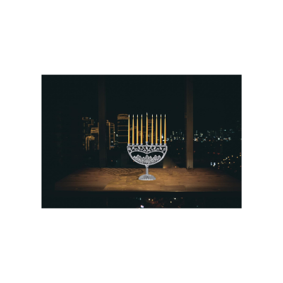 Candelabro de cristal com velas amarelas acesas numa mesa à noite