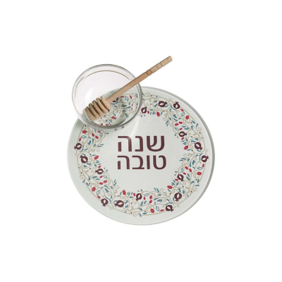 Prato branco com padrão floral e texto em hebraico, pequeno recipiente de vidro com pegador de mel