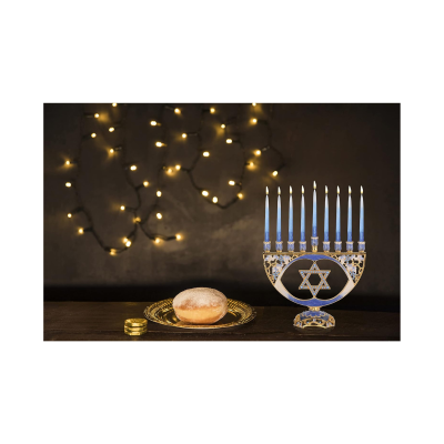 Menorá azul dourada com velas e doce em prato dourado numa mesa com luzes de fundo