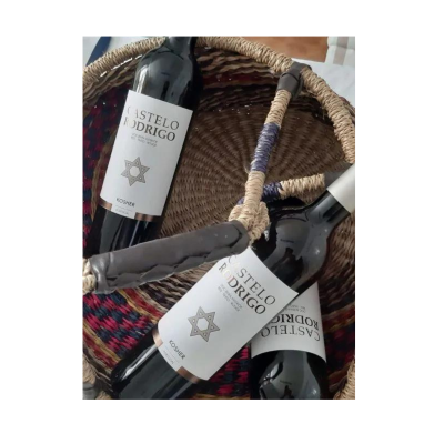 Três garrafas de vinho tinto Castelo Rodrigo numa cesta de verga colorida