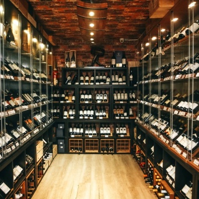 Adega organizada com garrafas de vinho em prateleiras de madeira