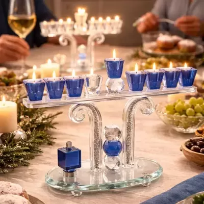 Candelabro menorá de vidro e cristal com velas acesas numa mesa decorada.