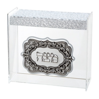 Caixa transparente com tampa prateada e placa com escrita hebraica decorativa