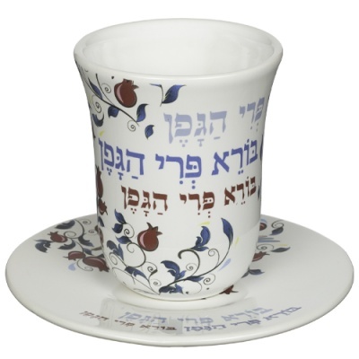 Conjunto de chávena e prato de porcelana com padrão de romãs e texto em hebraico