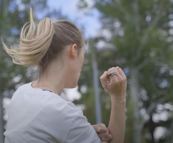 Mulher com anel prateado na mão direita em ambiente exterior