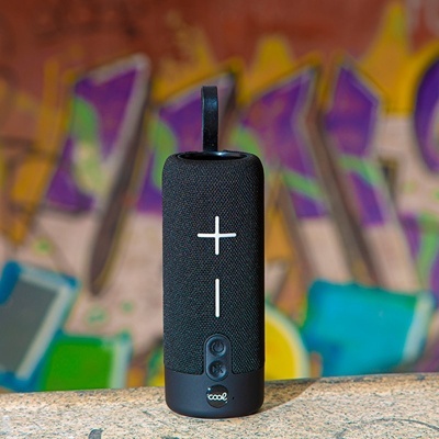 Coluna de som portátil preta com botões e alça em fundo de graffiti colorido