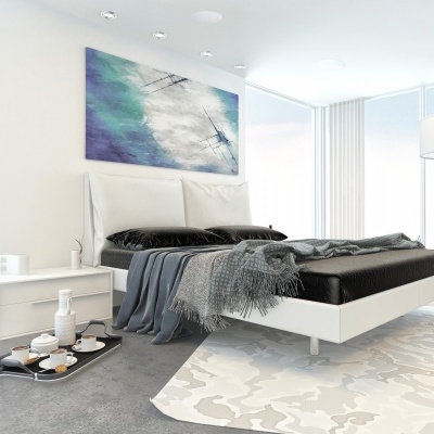 Quarto moderno com cama branca, roupa de cama preta, manta cinzenta, mesa de cabeceira branca, tapete claro e candeeiro de pé