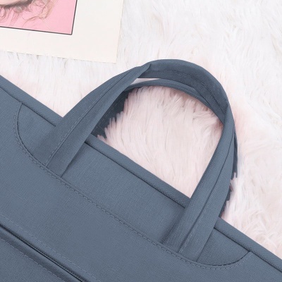 Mala azul com alças em tecido sobre superfície branca macia