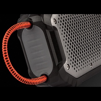 Coluna portátil preta com cabo laranja e preto sobre fundo negro