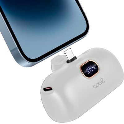 Bateria portátil branca com ecrã digital ao lado de smartphone prateado