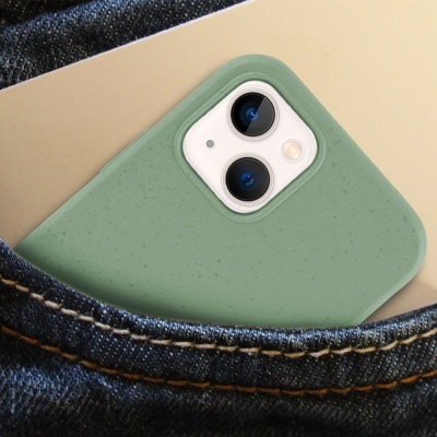 Smartphone branco com capa verde clara no bolso de calças de ganga azul escuro.