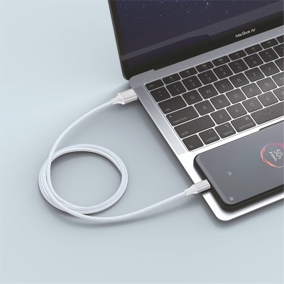 Cabo USB branco trançado conectado a portátil cinza e smartphone preto em superfície cinza
