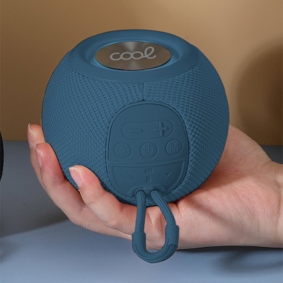 Coluna portátil Bluetooth azul redonda com botões e texto 'cool' na parte superior.