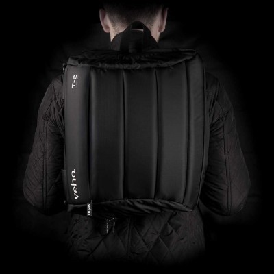 Mochila preta acolchoada com etiquetas 'verho.' e 'Ti-2', usada por pessoa com casaco preto