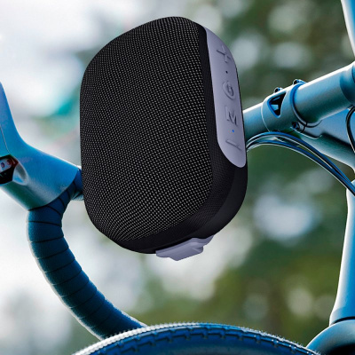 Coluna portátil preta com botões presa ao guidão de bicicleta azul