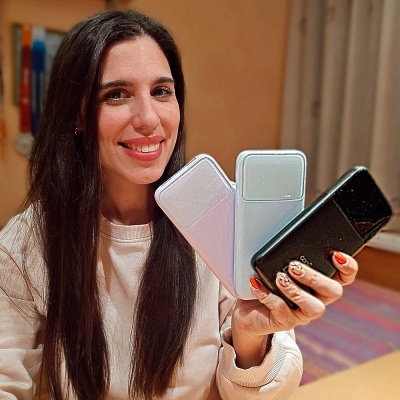 Mulher a segurar três telemóveis modernos em diferentes cores