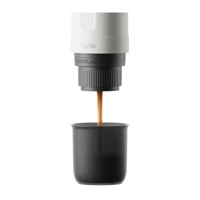 Dispositivo de café branco e cinzento a verter café num copo preto