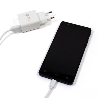 Smartphone preto ligado a carregador branco com logotipo coop