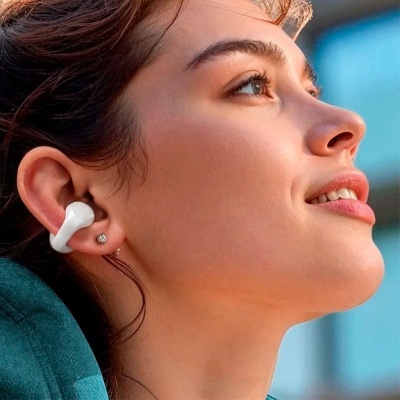 Mulher a usar auscultadores intra-auriculares brancos sem fios