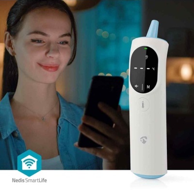 Termómetro digital branco com visor preto e mulher a usar telemóvel