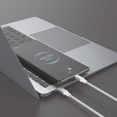 Computador portátil cinza com telemóvel preto a carregar