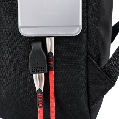 Smartphone cinzento com cabos USB conectados e mochila preta ao fundo