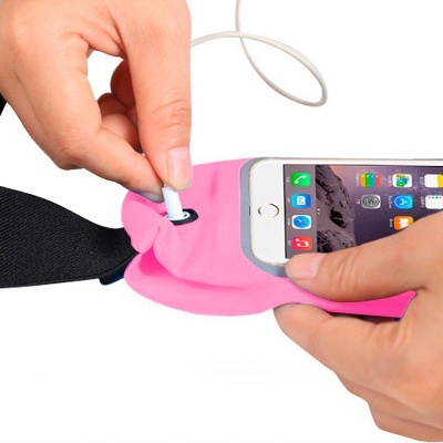 Suporte rosa para smartphone com fita preta, pessoa a colocar auscultadores brancos.