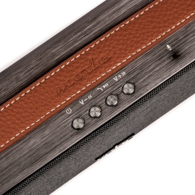 Coluna portátil com botões metálicos e faixa de couro castanho com a palavra 'mode' gravada