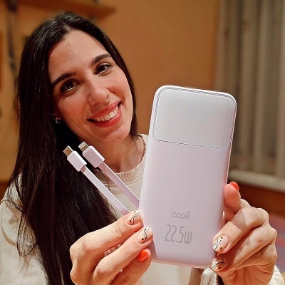 Mulher a segurar bateria externa branca com cabos USB-C e Lightning