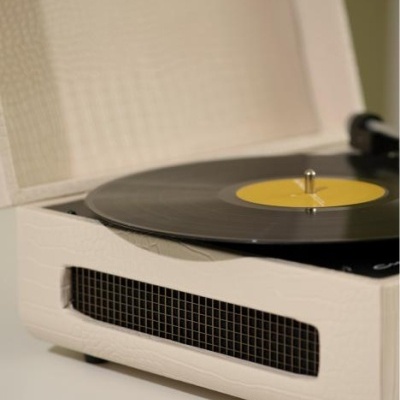 Gira-discos portátil branco com disco vinil preto e etiqueta amarela